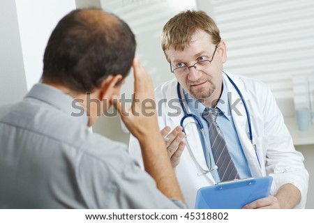 Stock photo: Doctor And Male Patient Having Headache At Clinic