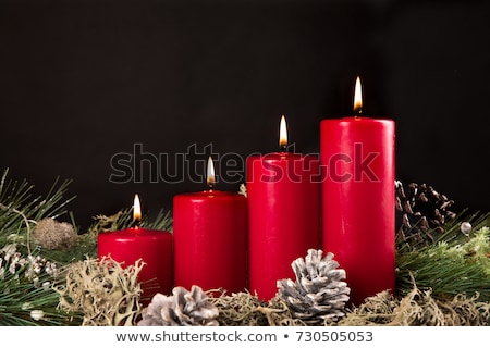 Stockfoto: A Burning Candle With Red Christmas Balls