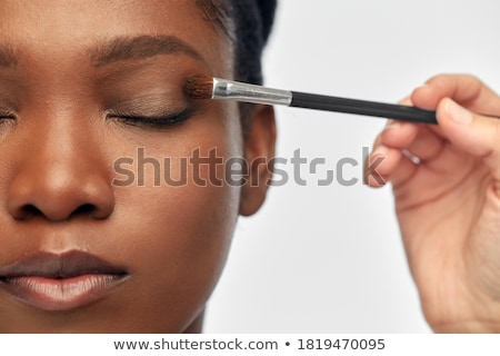 Foto stock: Woman Applying Shadows In Beauty Concept