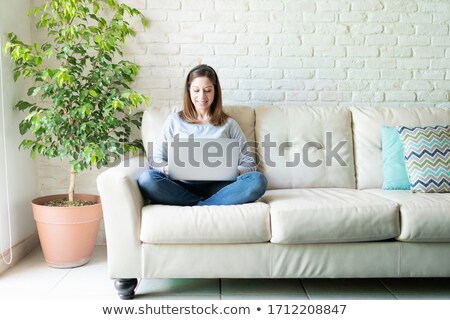 Stock photo: Portrait Of A Woman Sitting On A Couch