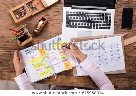 Foto d'archivio: Businesswoman Writing Schedule In Diary