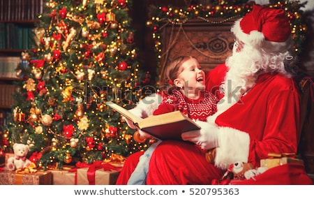 Stock fotó: Girl Hugging Santa At Home On Christmas