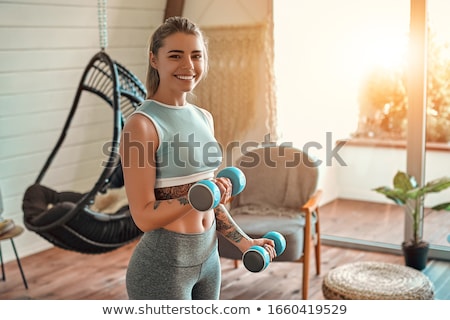 Stock fotó: Young Woman Exercising With Dumbbells