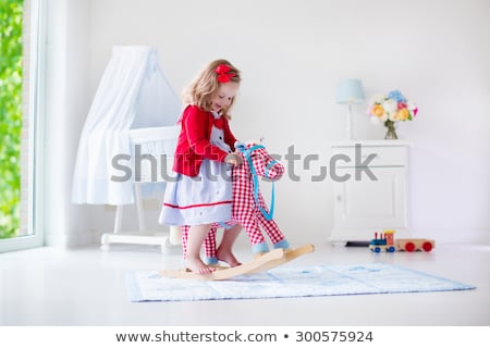 Foto stock: Little Girls Riding On Play Horses In Kindergarten