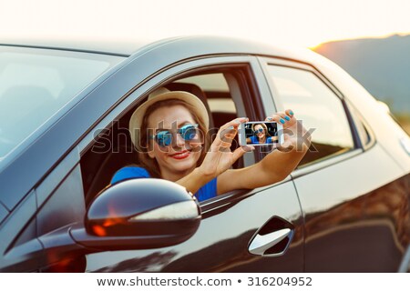 Stockfoto: Woman In Hat And Sunglasses Making Self Portrait Sitting In The