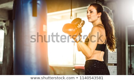 Foto stock: Female Boxer Posing With Punching Bag