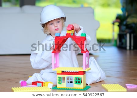 Сток-фото: Cute Little Baby Girl Play With Plastic Bricks Sitting Indoors On A Tiles Floor