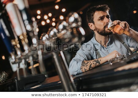 Сток-фото: Man Drinking Beer And Smoking Cigarette At Pub In The Night Club