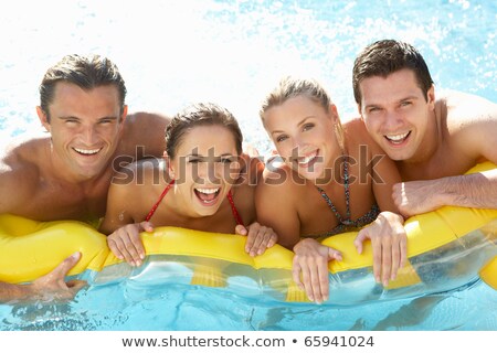 Foto d'archivio: Four Friends Having Fun In The Swimming Pool