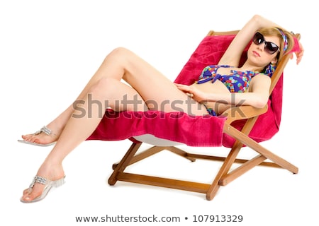 Foto d'archivio: Smiling Young Woman Sunbathing In Lounge On Beach