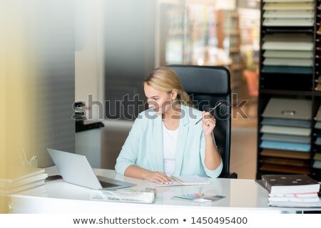 Foto stock: Clever Young Female Student Sitting By Desk While Watching Online Video