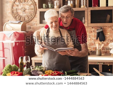 Stockfoto: Mature Couple Cooking With Cookbook