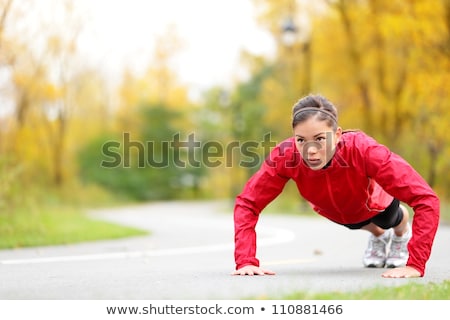 Foto d'archivio: Female Fitness Athlete Doing Push Ups Workout Outside