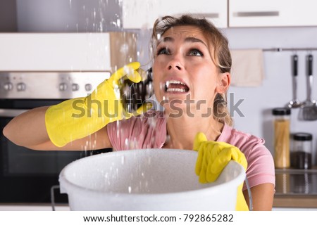 Stock fotó: Woman Collecting Water Leaking From Ceiling In Bucket