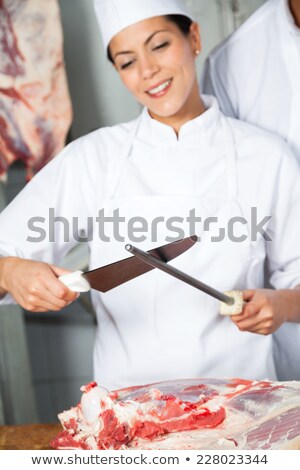 Stockfoto: Smiling Butcher Or Chef Sharpens Knife