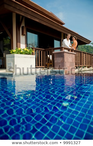 Foto d'archivio: Young Attractive Couple Relaxing In A Warm Tropical Pool
