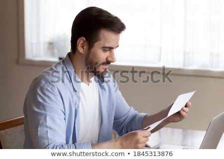 Stockfoto: Young Man Reading Written Agreements For Work