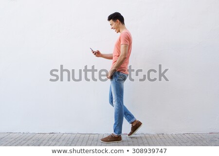 商業照片: Man Text Messaging On Sidewalk