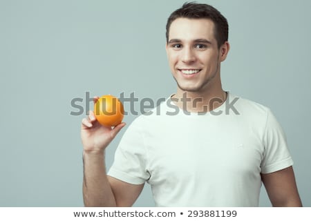Happy Muscular Man Holding Orange Over White Background Сток-фото © Augustino