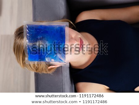 Stock photo: Woman Applying Ice Gel Pack On Forehead