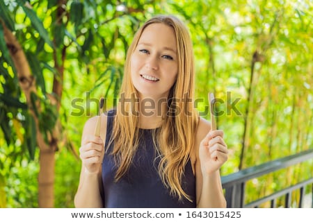 Stockfoto: Bamboo Toothbrush On A Background Of Green Growing Bamboo