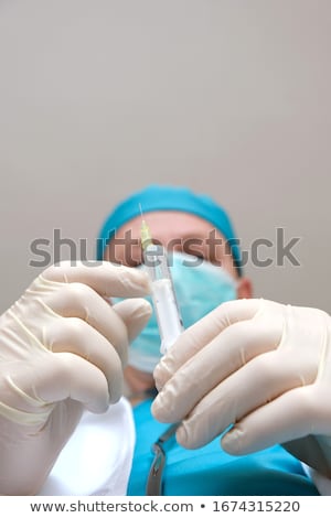 Foto stock: Doctors Hand In A White Glove Holding Syringe