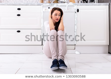 Zdjęcia stock: Upset Woman Sitting In Front Of Damaged Dishwasher