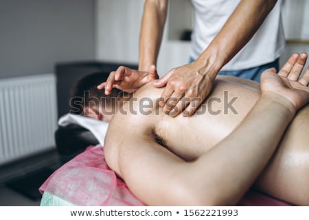 Foto stock: Masseur Massaging Face Of A Beautiful Young Woman Lying On The