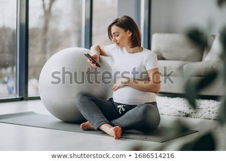 Foto d'archivio: Pretty Young Female Using A Pilates Ball