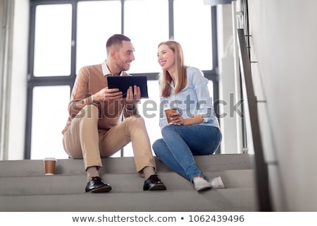 Foto stock: Man And Woman With Tablet Pc And Coffee On Stairs