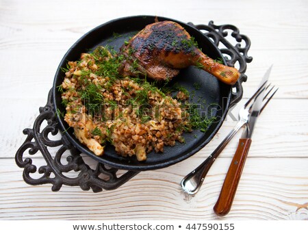 Zdjęcia stock: Chicken Grilling With A Side Dish Of Buckwheat On A Black Metal