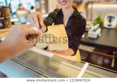 Сток-фото: Customer Trying Bit Of Cheese At The Deli Counter