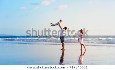 Stock foto: Happy Family Father Mother Son With Fun Along Sunset Sea Surf On Black