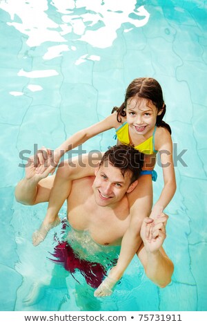 Fille de famille heureuse dans la piscine est assise sur l'épaule de son père [[stock_photo]] © Pressmaster