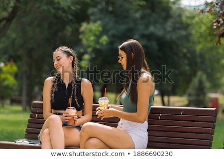 Two Girls Gossiping On Bench At Garden Stock photo © Gorgev