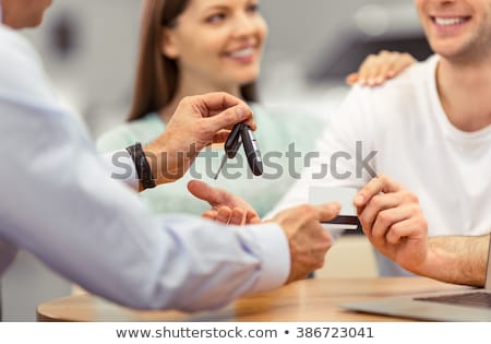 Stock photo: Smiling Couple Holding Credit Card To Buy A Car