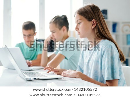 Pretty Girl Using Laptop On Background Of Her Classmates Foto stock © Pressmaster