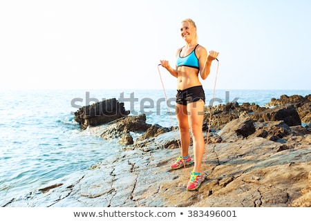 Zdjęcia stock: Athlete Woman Doing Sport Exercising On The Rocks By The Sea