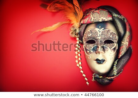 Foto stock: Carnival Mask And A Red Christmas Ball On A Golden Abstract Back