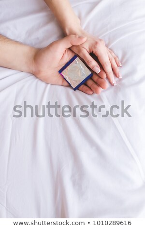 Foto stock: Close Up Of Couple With A Condom On Bed