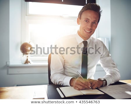 Stock photo: Smiling Businessman Seated At Desk