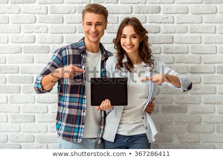 Foto stock: Young Man Holding A Black Tablet Isolated On White