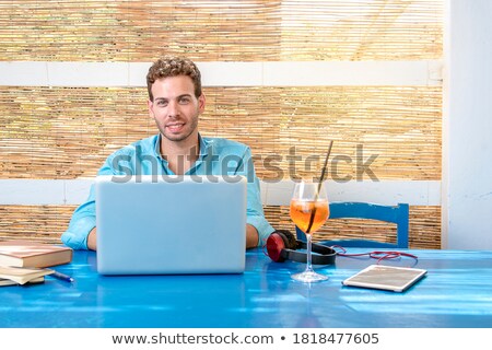 Сток-фото: Man With Tablet Pc And Earphones Sitting At Cafe