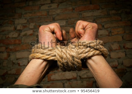 Foto stock: Man With Hands Tied Up With Rope