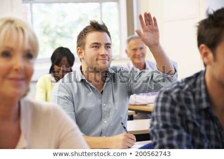 [[stock_photo]]: A Student Asks A Question To The Teacher That Writes On The Blac