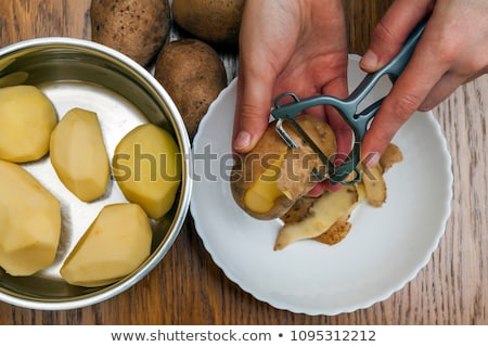 Stock photo: Potatoes With Peeler And Peeled Skin