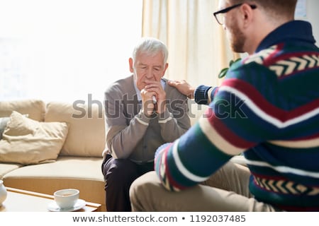 Foto stock: Senior Man Sharing Problems With Doctor