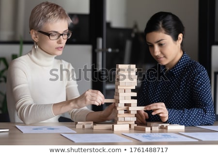 Stockfoto: Team Of Young Business People Build A Wooden Construction In The