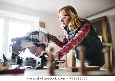 [[stock_photo]]: Woman Sawing Wooden Plank With Electric Saw