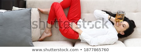 Foto stock: Alcoholic Lying On Sofa And Drinking Whiskey